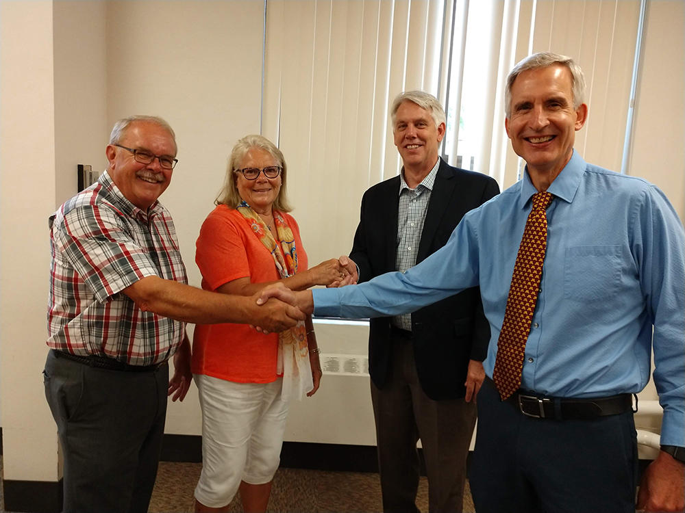 Dennis and Victoria Johnson shake hands with CFANS Dean Brian Buhr and Associate Dean Mike White